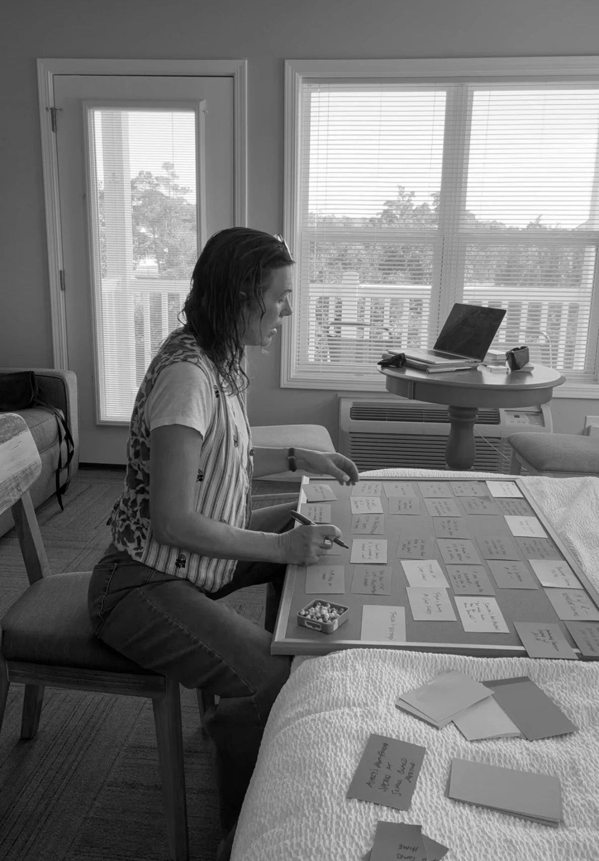 Diane working through her story with a board of handwritten scene cards by a window